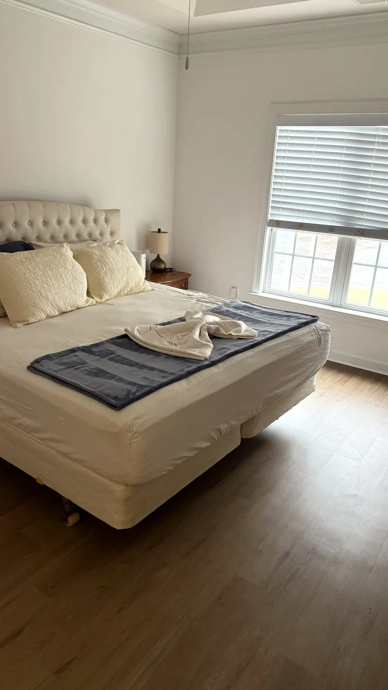 Bedroom with freshly made bed and folded towels